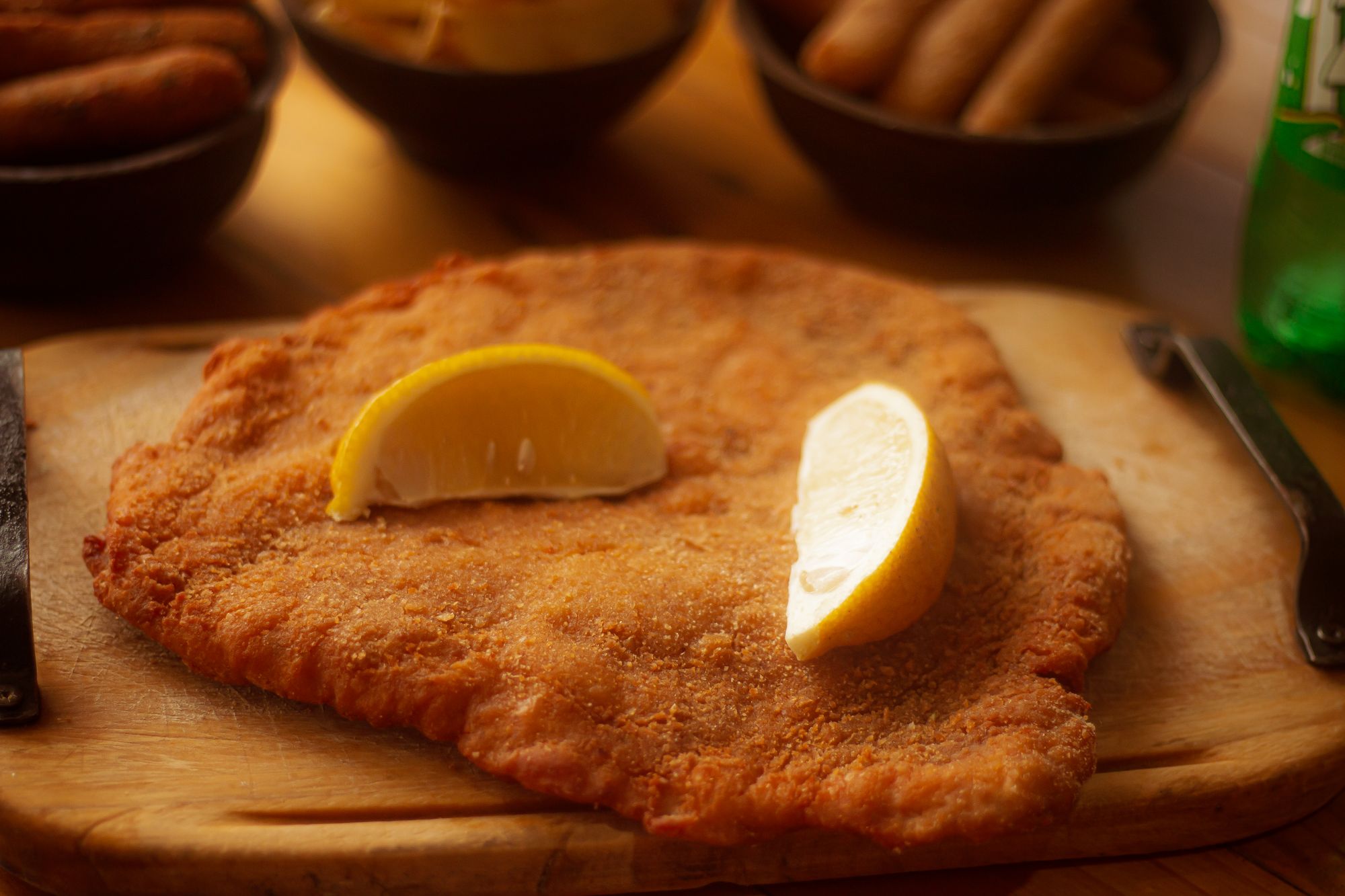 Goldbraunes Wiener Schnitzel mit Zitrone auf Holzbrett